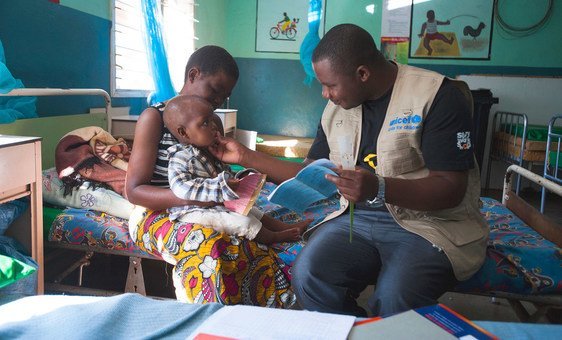 Une mère tient son fils de 18 mois dans ses bras pendant qu'il subit un examen médical à l'hôpital du district de Balaka, au Malawi (Archives)